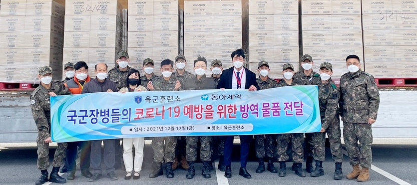 육군훈련소 군 장병들이 동아제약이 기부한 황사 방역용 마스크를 실은 트럭 앞에서 기념사진을 찍고 있다. 사진=동아제약