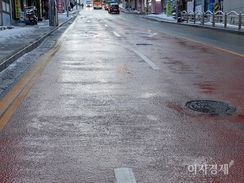 반면, 이면도로는 염화칼슘을 뿌려 차량이 경사 45℃ 의 도로도 평소처럼 달리고 있다. 이면도로 인도에도 염화칼슘이 뿌려졌다. 사진=김진이 기자