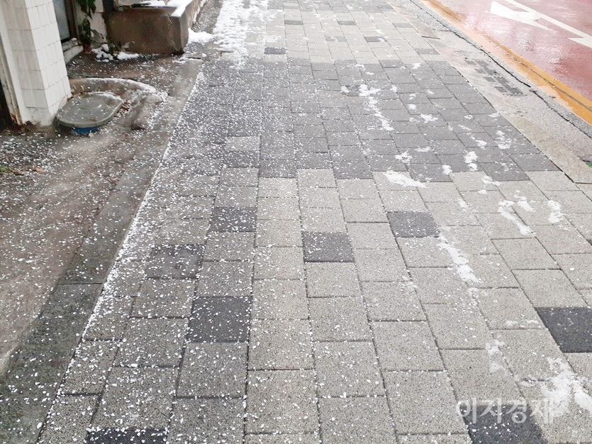 반면, 이면도로는 염화칼슘을 뿌려 차량이 경사 45℃ 의 도로도 평소처럼 달리고 있다. 이면도로 인도에도 염화칼슘이 뿌려졌다. 사진=김진이 기자