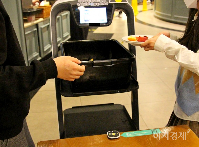 고객이 이용한 그룻 등을 푸드봇에 실고 있다. 사진=김진이 기자