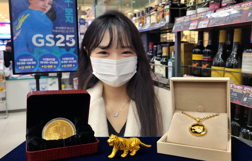 모델이 GS25 매장에서 임인년 호랑이 해 관련 금 상품을 들고 있다. 사진= GS25