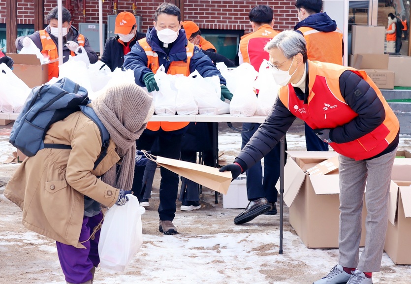 SK에너지 조경목(오른쪽 첫 번째) 사장이 구성원과 함께 명동밥집에서 한끼나눔 봉사활동을 진행하고 있다. 사진=SK이노베이션