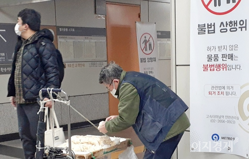 지하철7호선 고속터미널역에서 9호선 고속터미널역으로 가는 환승 통로에 엿장수가 있다. 지하철 역사 내에서 상행위가 불법임을 알지만, 1000원짜리 엿 한 봉지를 팔아야 가족애 입에 풀칠을 할 수 있기 때문이다. 고갸를 외로 돌린 청년의 모습이 안타깝다. 사진=김진이 기자