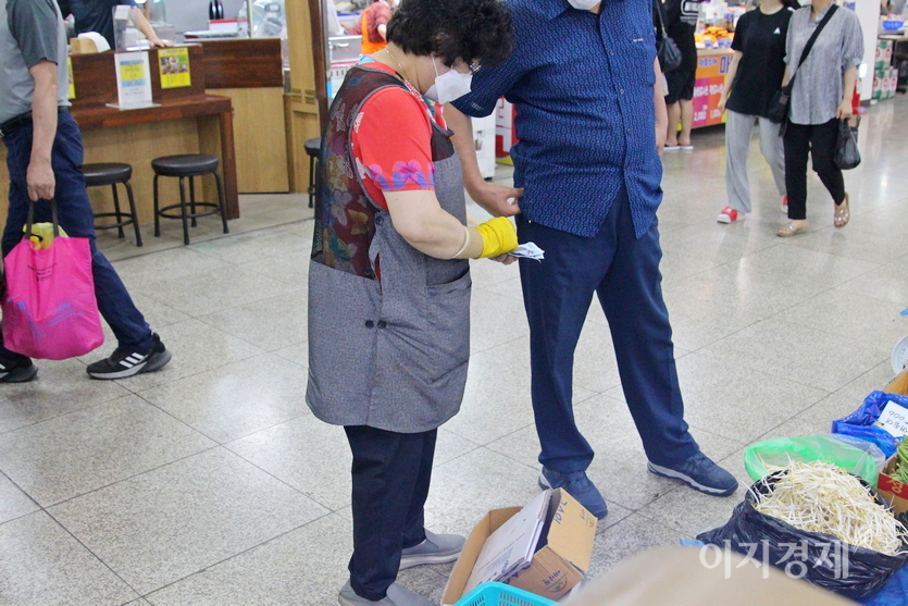 중앙시장 상인이 돈을 셈하고 있다. 사진=정수남 기자