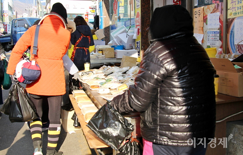 골목 양 끝에 각각 자리한 전집이 분주하다. 떡집도 대목을 톡톡히 누리고 있다. 사진=정수남 기자