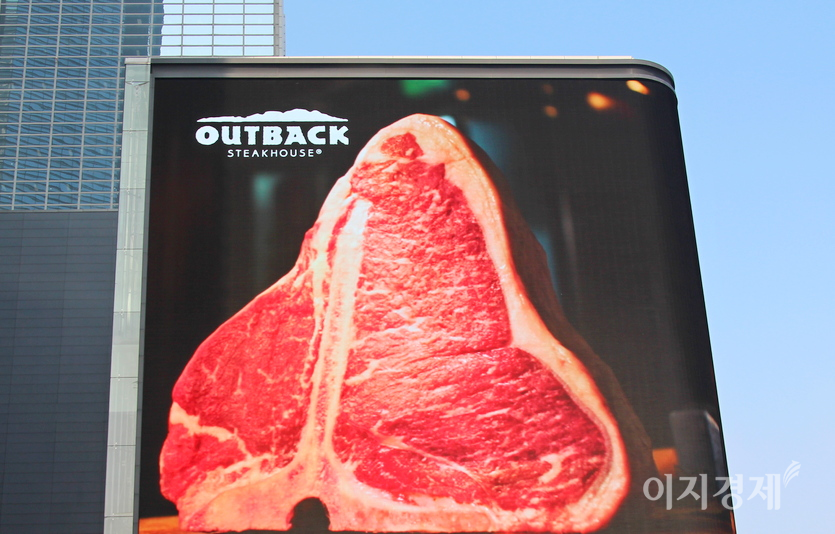 아웃백의 또 다른 주력인 티본 스테이크. bhc가 인수 후 삼성동 SM타운 외벽 LCD 광고 판에서 아웃백 홍보를 시작했다. 사진=정윤서 기자