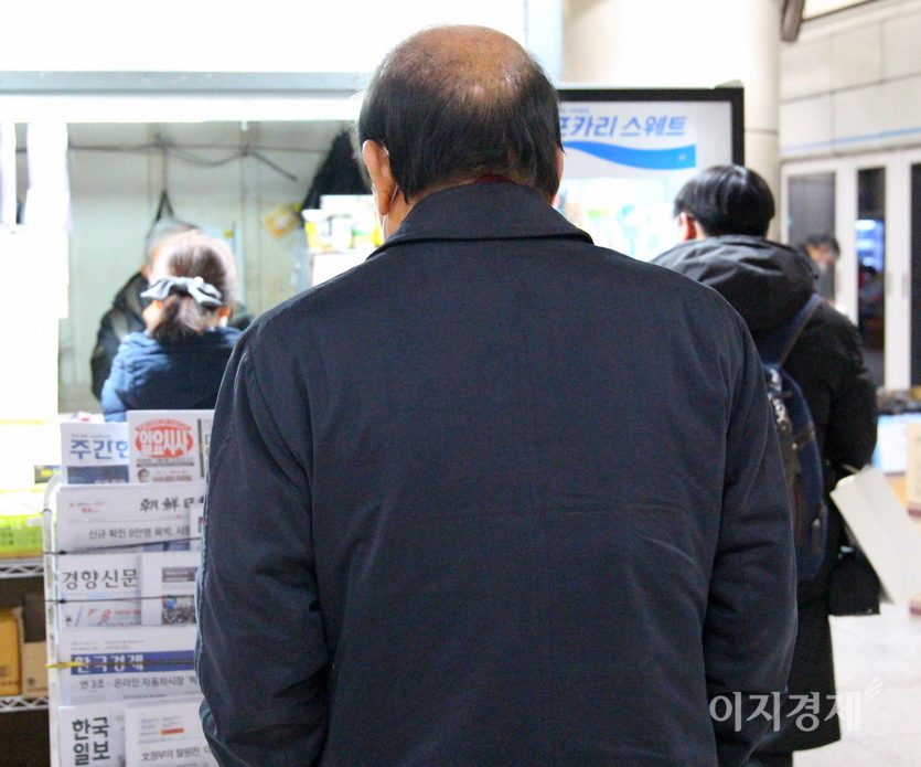 한 중년 남성이 신문 판매대에서 이지경제 자매지인 일요시사 등을 살피고 있다. 사진=정수남