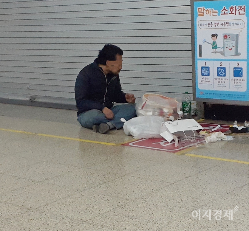 5555-한 노숙자가 점포에서 내놓은 음식울 쓰레기에서 국수 가닥을 먹고 있다. 이 노숙인은 함께 있는 탄산음료로 입가심을 했다. 사진=정수남 기자