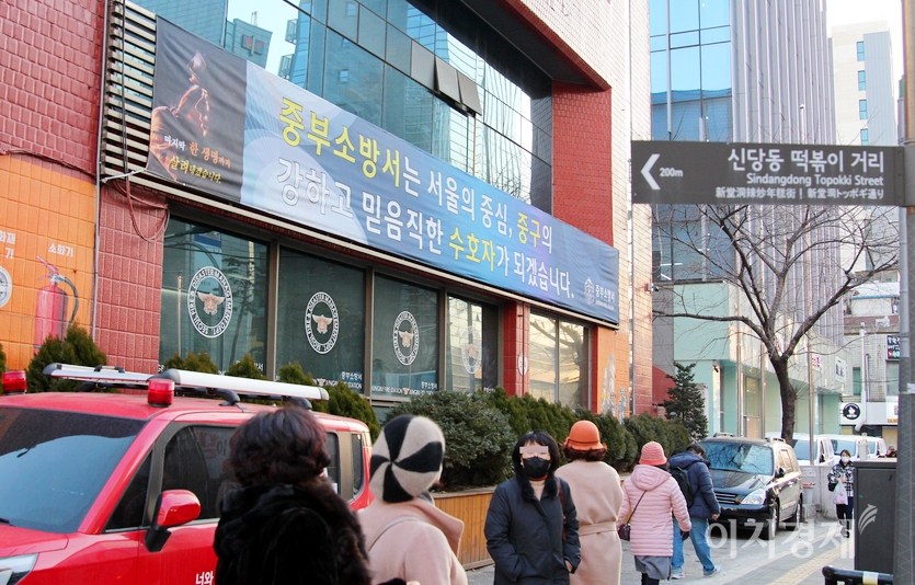 중년으로 보이는 여성 네명이 서울 중부소방서에서 100여미터 떨어진 신당동 떡볶이 거리를 찾고 있다. 머리 위에 이정표가 보인다. 사진=정윤서 기자.