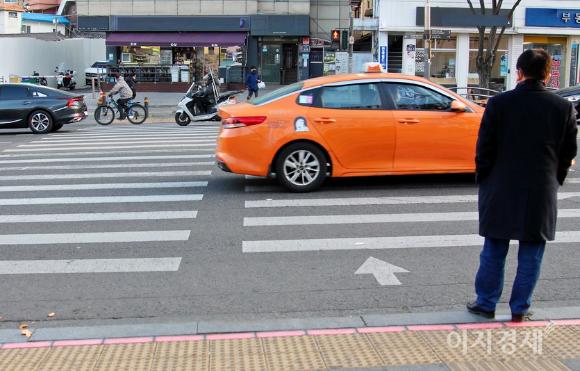 입식 신호등과 바닥 신호등에 빨간불이 들어왔다. 보행자가 대기하고 있는 가운데, 1톤 용달차가 달리다, 사진=김진이 기자