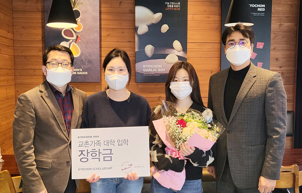 교촌에프앤비 관계자가 장학금 수혜 가맹점주 가족과 기념촬영을 하고 있다. 사진=교촌에프앤비