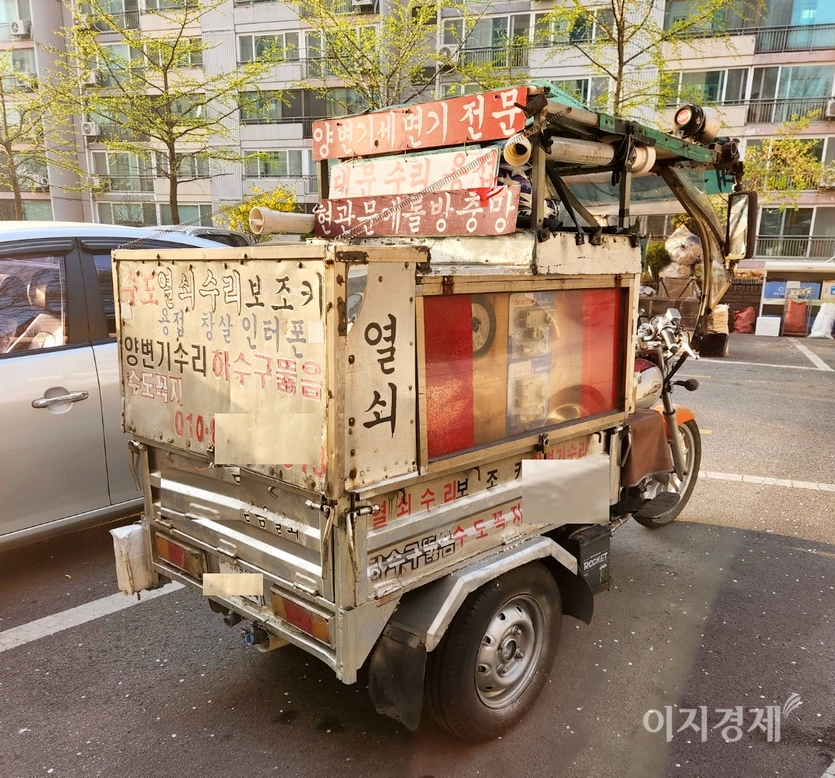 열쇠 수리와 막힌 변기를 뚫고, 대문 수리 등을 전문으로 한다는 문구가 이륜차에 붙어있다. 1960년대와 1970년대 굴뚝을 뚫는 직업을 연상케 한다. 사진=정윤서 기자