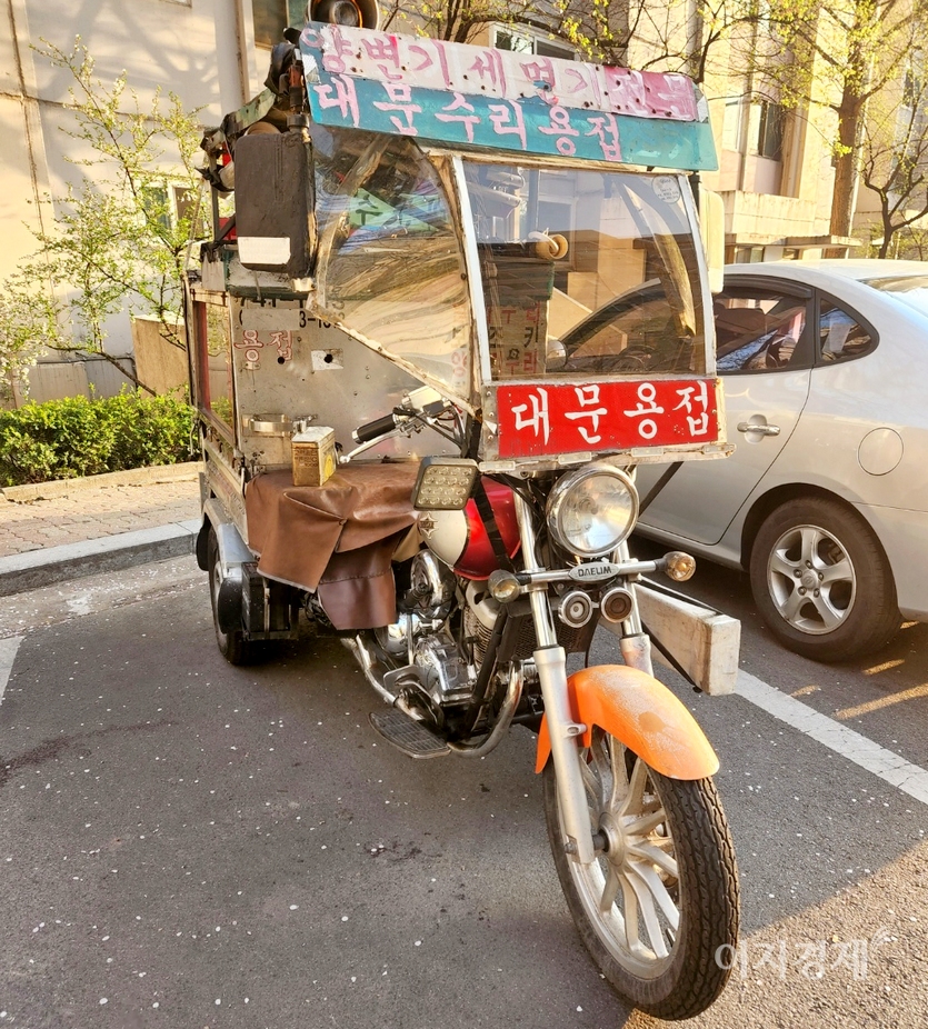 열쇠 수리와 막힌 변기를 뚫고, 대문 수리 등을 전문으로 한다는 문구가 이륜차에 붙어있다. 1960년대와 1970년대 굴뚝을 뚫는 직업을 연상케 한다. 사진=정윤서 기자