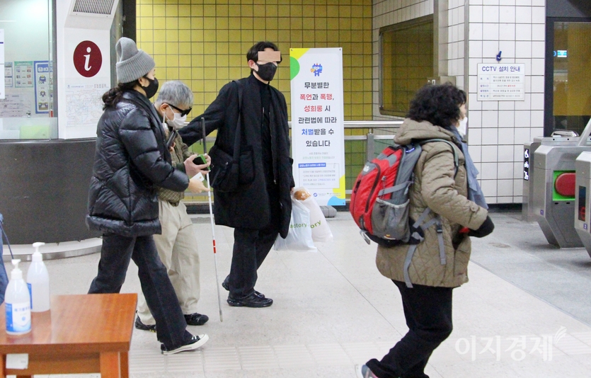 안면이 없던 20대 남녀가 시각 장애인을 개찰구로 함께 안내하고 있다. 사진=이승열 기자