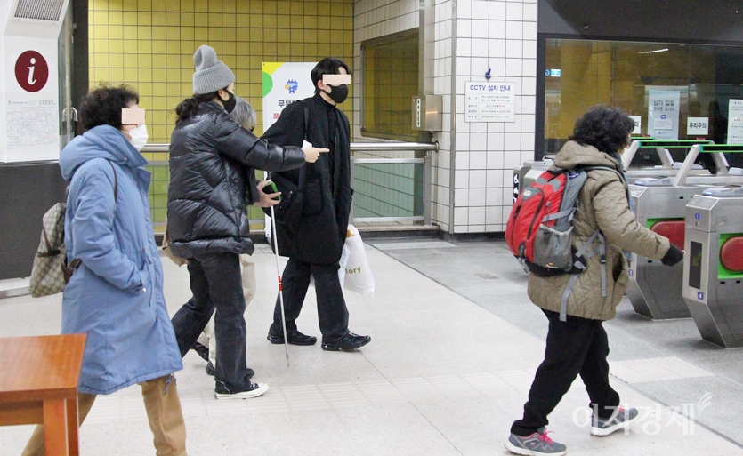 안면이 없던 20대 남녀가 시각 장애인을 개찰구로 함께 안내하고 있다. 사진=이승열 기자