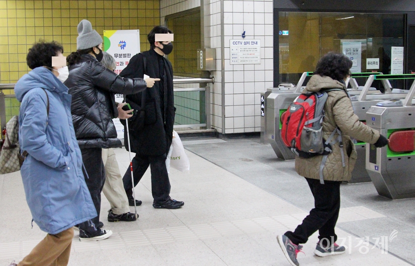안면이 없던 20대 남녀가 시각 장애인을 개찰구로 함께 안내하고 있다. 사진=이승열 기자