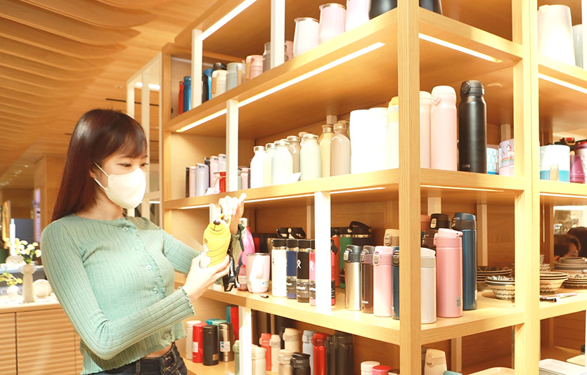 롯데백화점은  ‘지구의 날’을 맞아 일상 속 친환경 소비를 독려하는 콘텐츠와 이벤트를 선보인다. 본점 메종아카이브 매장에서 텀블러를 구경하는 고객. 사진=롯데백화점 