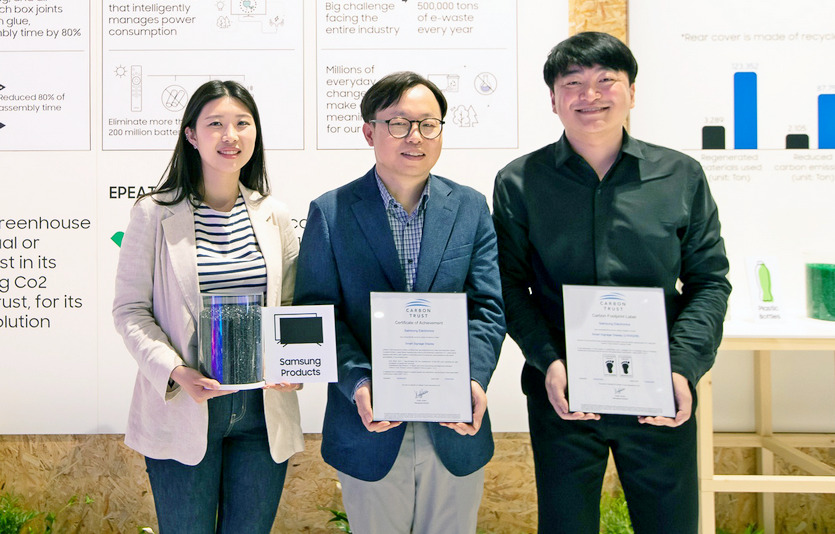 삼성전자 영상디스플레이사업부 이종포(가운데) 상무가 개발자와 함께 사이니지 제품 탄소 발자국 인증서와 제품에 활용되는 재생 플라스틱을 들고 있다. 사진=삼성전자