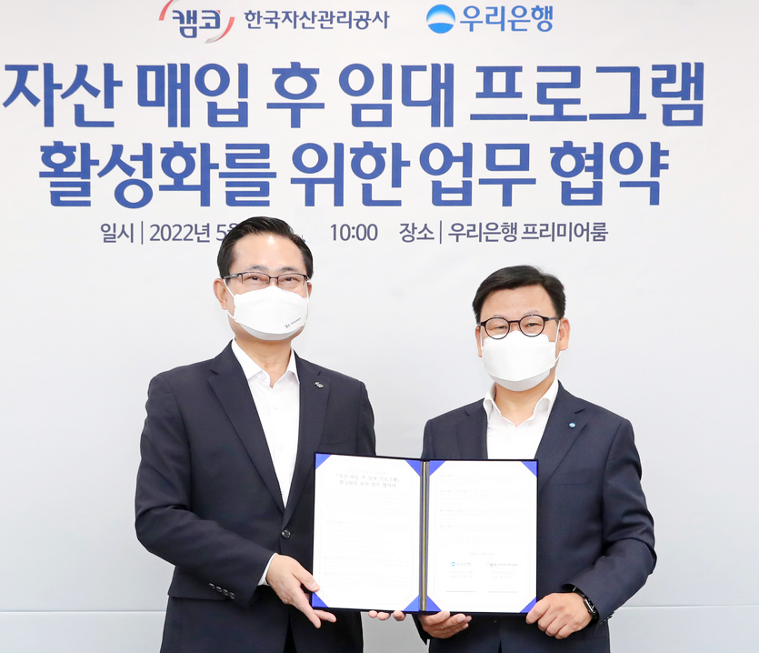 (오른쪽부터)이원덕 우리은행장과 권남주 한국자산관리공사 사장이 기념사진을 찟고 있다.