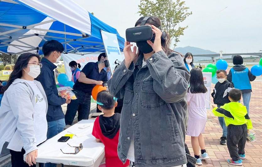 제너시스BBQ그룹의 올리버스가 남양주 한강시민공원에서 VR영상을 통해 아동학대 근절의 중요성을 알리고 있다. 사진=제너시스BBQ