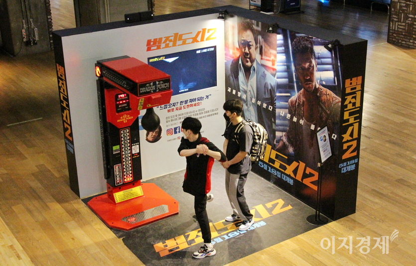 시사회장에 설치된 펀치볼. 20대 남성이 극중 마동석처럼 주먹을 휘두르며 펀치볼을 치고 있다. 사진=정수남 기자