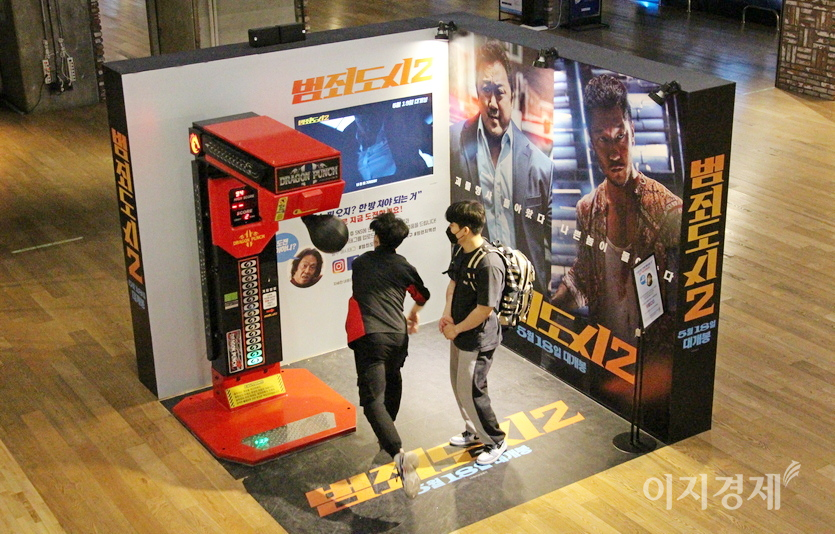 시사회장에 설치된 펀치볼. 20대 남성이 극중 마동석처럼 주먹을 휘두르며 펀치볼을 치고 있다. 사진=정수남 기자