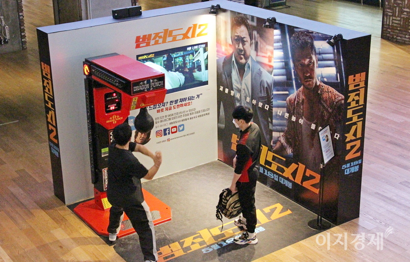 시사회장에 설치된 펀치볼. 20대 남성이 극중 마동석처럼 주먹을 휘두르며 펀치볼을 치고 있다. 사진=정수남 기자