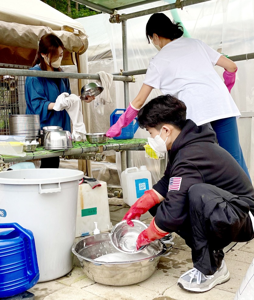 장희령 씨 등 봉사단원이 사료그릇 등을 세척하고 있다. 사진=KBI