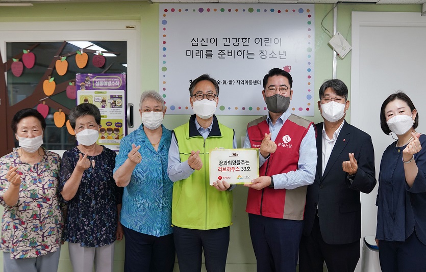 롯데건설 주택사업본부 이부용 본부장(오른쪽에서 세 번째), 유성훈 금천구청장(오른쪽 네 번째)과 관계자들이 함께 기증판을 전달하고 있다.jpg