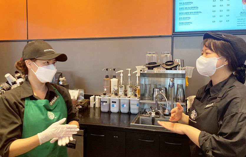 2022년 하반기 장애인 바리스타로 입사한 김정희 바리스타(왼쪽)가 동료 파트너와 수어로 대화를 나누고 있다. 사진=스타벅스 코리아