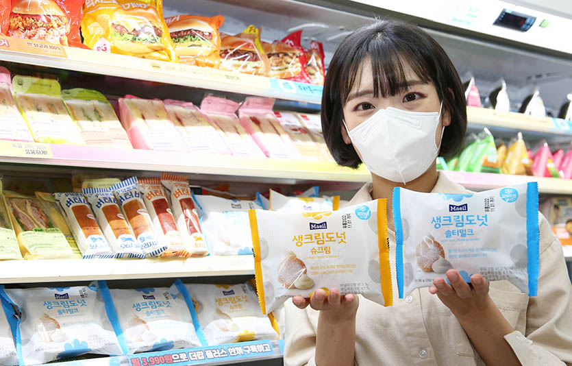 모델이 GS25에서 판매하는 매일우유 생크림도넛 슈크림, 솔티밀크를 들고 포즈를 취하고 있다. 사진=GS리테일