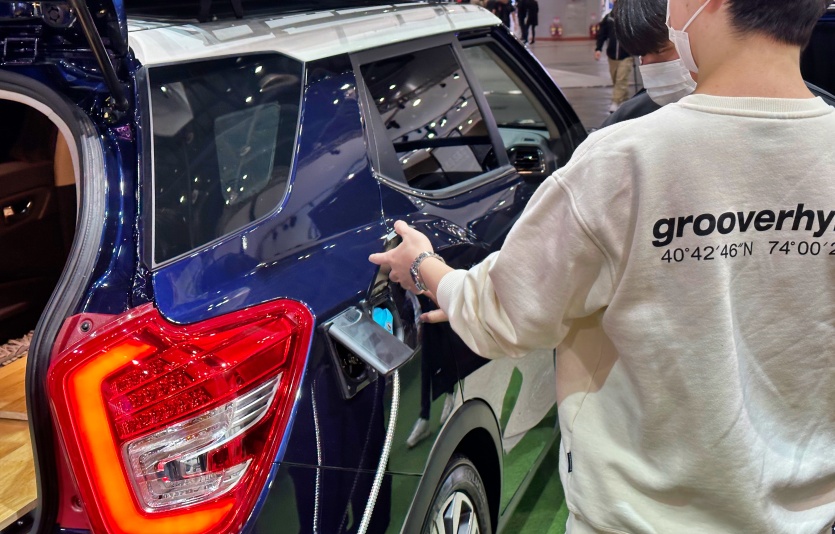 관람객들이 차량 주유구를 살펴보고 있다. 사진=최준 기자