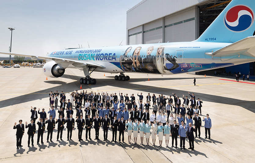 대한항공이 2030부산세계박람회 유치 지원을 위해 블랙핑크가 입혀진 특별 임시편을 국제박람회기구 총회가 열리는 프랑스 파리 노선에 투입한다. 대한항공 부산세계박람회 유치 기원 블랙핑크 래핑 항공기 (보잉777-300ER)[사진2,3]대한항공 직원들이 부산세계박람회 유치 기원 블랙핑크 래핑 대한항공 항공기 (보잉777-300ER) 앞에서 기념 사진을 촬영하는 모습.사진=대한항공