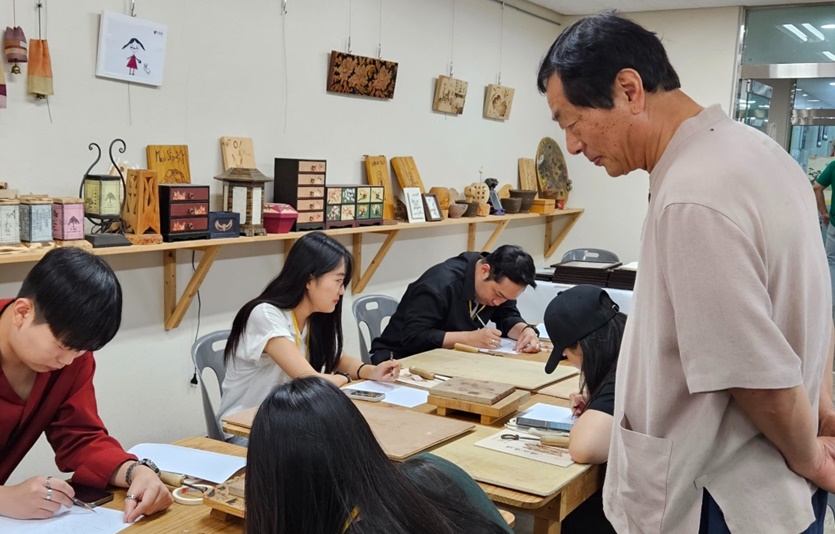 인간문화재 지킴이 참여마당 참가자들이 충북 보은 전통공예체험학교에서 국가무형문화재 136호 낙화장 김영조 선생에게 낙화를 배우고 체험하고 있다. 사진=한독
