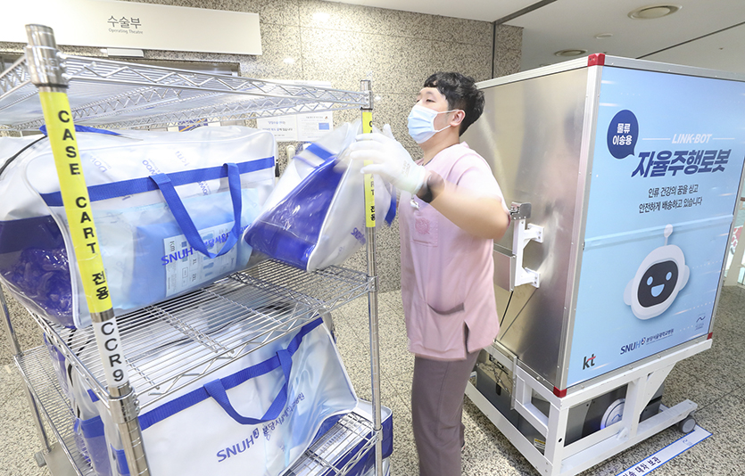 분당서울대병원 직원이 본관 3층 수술실 앞에 도착한 ‘자동이송 로봇’에서 환자 수술에 필요한 물품을 꺼내 수술실로 이동을 준비하고 있는 모습. 사진=KT