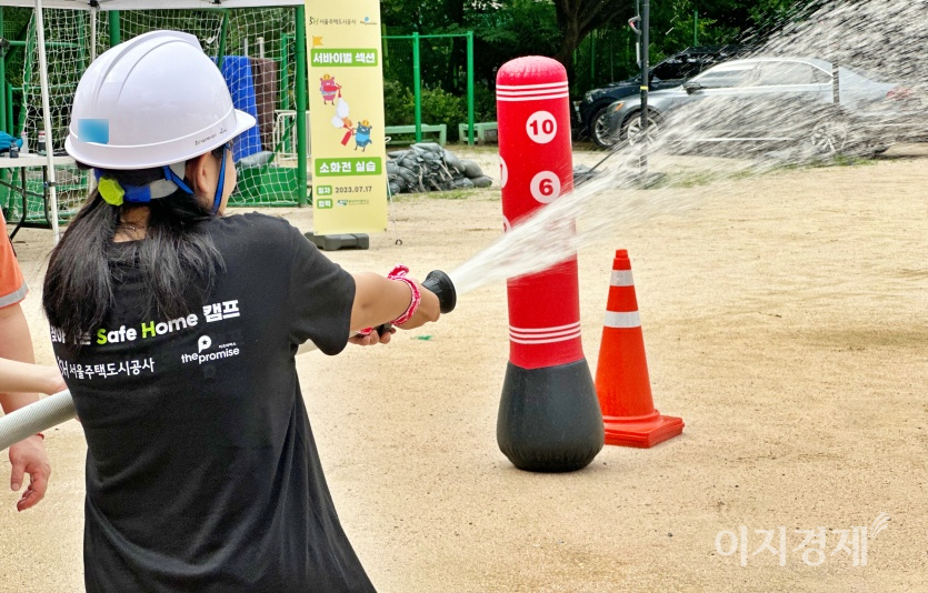 한 학생이 학교 소화전을 들고 방수하고 있다. 사진=최준 기자