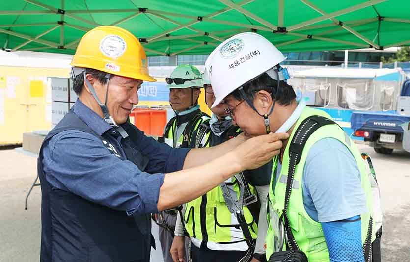 이학재 인천국제공항공사사장(사진 왼쪽)이 현장 근로자에게 폭염예방 용품(아이스 넥 링)을 전달하고 있다. 사진=인천국제공항공사