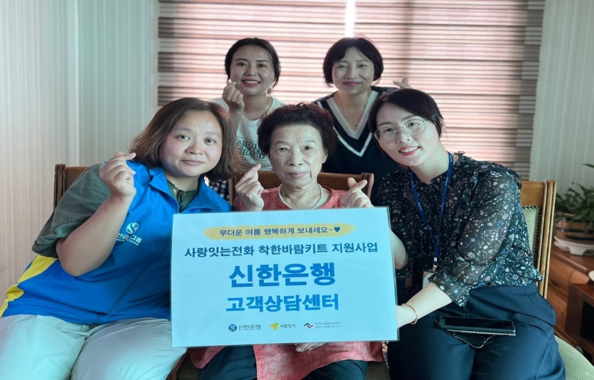 신한은행 고객상담센터 및 서호노인복지관 직원들이 독거 어르신 자택을 방문해 여름나기를 위한 ‘착한바람 키트’를 전달하는 모습. 사진=신한은행
