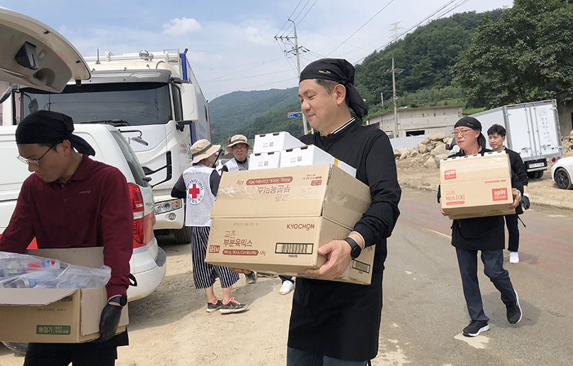 교촌에프앤비 임직원 봉사단과 교촌치킨 가맹점주들이 경북 예천군 감천면 수해현장에 방문해 치킨 나눔 활동을 진행하고 있다. 사진=교촌에프앤비