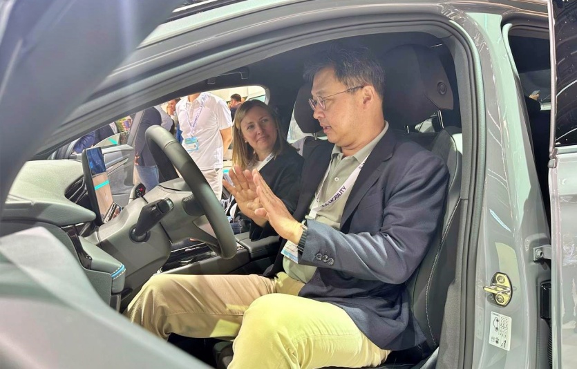 최재원 SK그룹 수석부회장이 4일(현지시간) 독일 뮌헨 메세 전시장을 찾아 폭스바겐 관계자로부터 ID.7 차량에 대한 설명을 듣고 있다. 사진=SK온