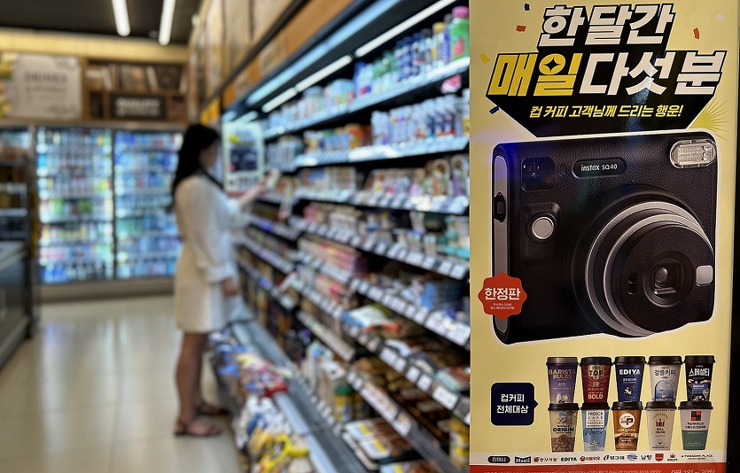 [이미지2] 이마트24 매장에서 고객이 컵커피 행사 상품을 살펴보고 있다.jpg