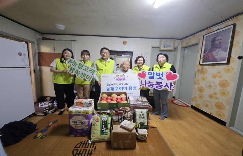 NH농협은행 고객행복센터 김성훈 센터장(왼쪽에서 세번째)과 직원들이 어르신과 기념사진을 촬영하고 있다. 사진=농협은행