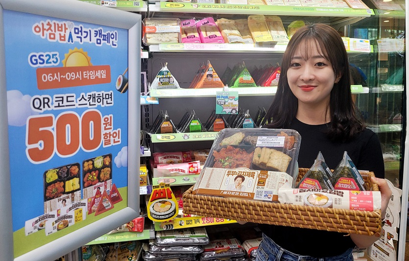 GS25에서 모델이 아침밥먹기캠페인 상품을 들고 포즈를 취하고 있다.jpg