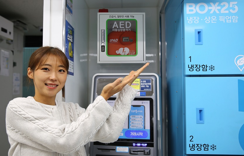 모델이 GS25에 설치된 자동심장충격기(AED)를 가리키고 있다.jpg