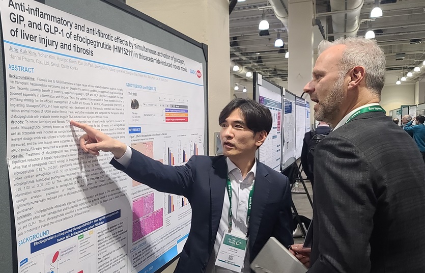 한미약품 R&D센터 김정국 연구원(왼쪽)이 지난 11일(현지시각) 미국 보스턴에서 열린 미국간학회 국제학술대회(AASLD)에서 MASH 치료 혁신신약으로 개발중인 에포시페그트루타이드(LAPSTriple agonist)의 간 섬유화 개선 효능에 대해 설명하고 있다.