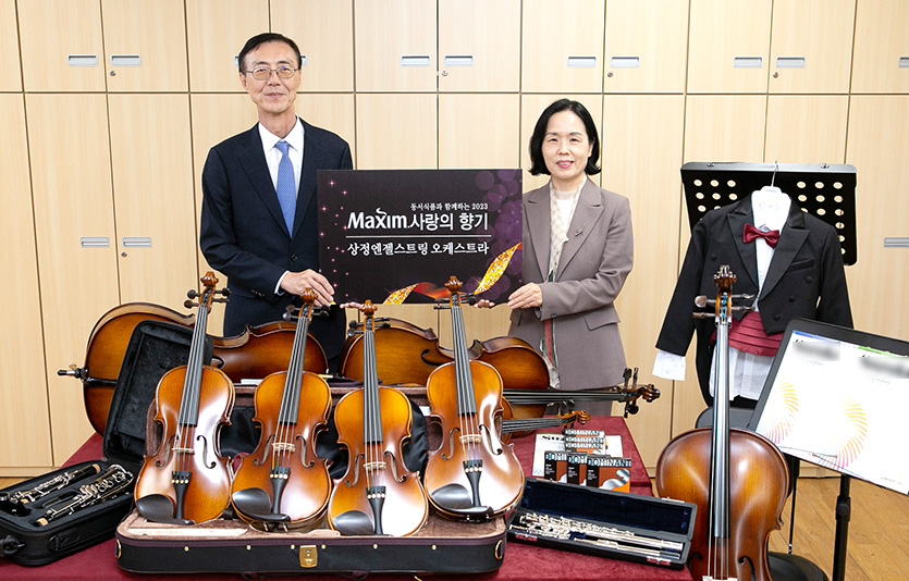 ‘제16회 맥심 사랑의 향기’ 악기 기증식에서 (왼쪽부터) 최상인 동서식품 홍보상무와 이숙경 인천상정초등학교 교장이 기증한 악기와 함께 기념촬영을 하고 있다. 사진=동서식품