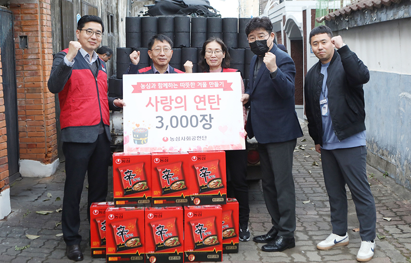 농심 총무팀 직원들과 서울 상도4동 주민센터 관계자들이 사랑의 연탄 전달식에서 기념촬영을 하고 있다. 사진=농심