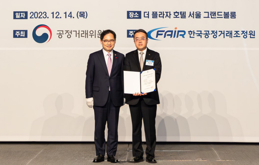 롯데건설 준법경영부문 조도휘 상무(오른쪽)가 한기정 공정거래위원장(왼쪽)으로부터 우수기업 평가증을 수여한 후 기념 촬영을 하고 있다. 사진=롯데건설