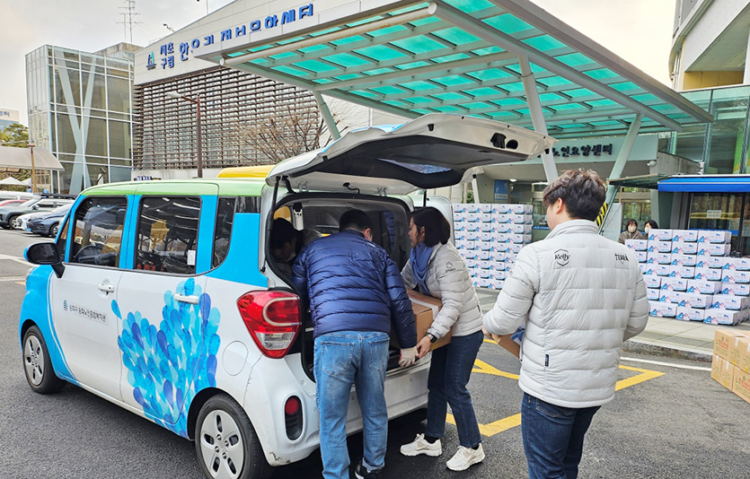 구립서초노인요양센터에서 진행된 '하이트진로 설명절 이웃사랑 나눔행사' 봉사에 참여한 임직원들이 사회복지기관 차량에 명절음식을 싣고 있다. 사진=하이트진로